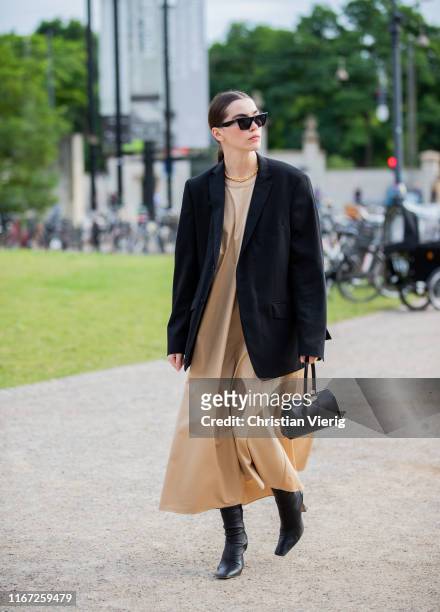 Guest is seen wearing beige dress, black blazer outside Samsøe & Samsøe during Copenhagen Fashion Week Spring/Summer 2020 on August 07, 2019 in...