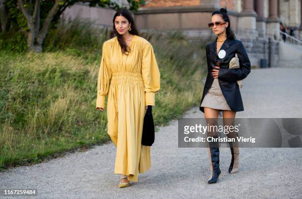Anna Rosa Vitiello wearing leather jacket, mini skit, two tone boots and Bettina Looney wearing yellow dress seen outside Samsøe & Samsøe during...