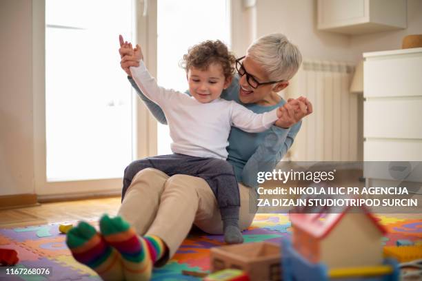 grandmother playing with her grandson - toddler-dancing stock pictures, royalty-free photos & images