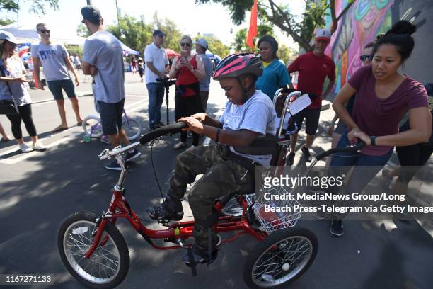 George Saquee is all smiles as he gets fitted for his brand new adaptive tricycle in Long Beach on Saturday, August 10, 2019. For the third year Los...