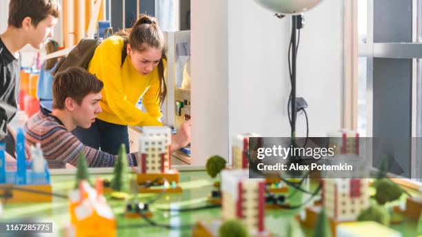 teenagers, boy, and girl, exploring electronic equipment on the exhibition of the hall of science and technology - children's museum stock pictures, royalty-free photos & images