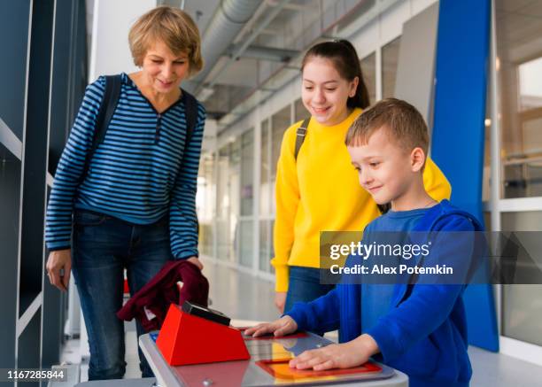 the family, the mature woman and kids, teenager girl and little boy, exploring bio electricity and electromagnetic induction in the hall of science - science exhibition stock pictures, royalty-free photos & images