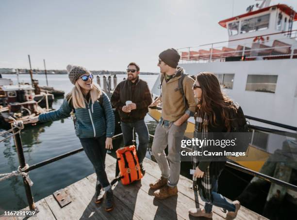 four young adult friends wait on the waterfront in portland, maine - the maine girls academy stock-fotos und bilder