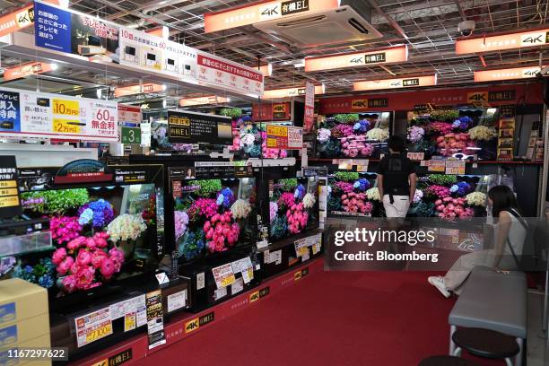 Customers look at 4K organic electroluminescence televisions at a Bic Camera Inc. Electronics store in Tokyo, Japan, on Thursday, Sept. 5, 2019....