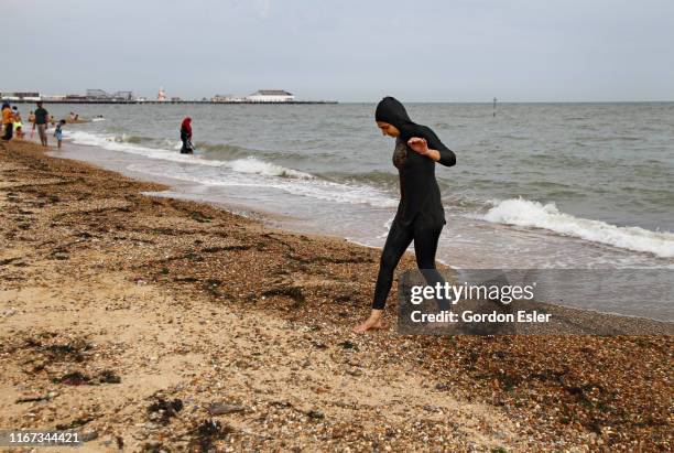 young woman in burkini on beach - burkini stock pictures, royalty-free photos & images