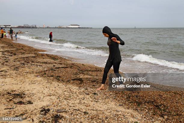 young woman in burkini on beach - burkini bildbanksfoton och bilder