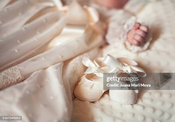 part of a baby's body, with christening attire - baby booties 個照片及圖片檔