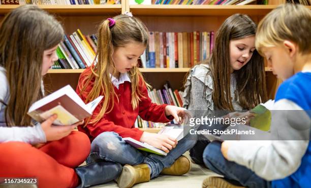 schoolkinderen een boek lezen - lezen stockfoto's en -beelden