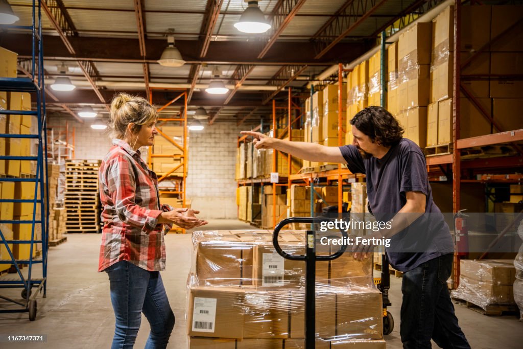 An industrial workplace bullying and harassment topic.  A male employee shouting and gesturing to a female coworker.