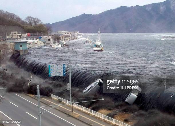 This picture taken by a Miyako City official on March 11, 2011 and released on March 18, 2011 shows a tsunami breeching an embankment and flowing...