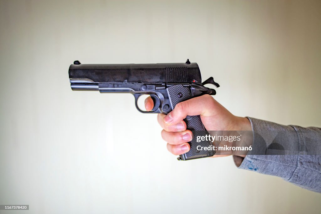 Close-Up Of Hands Holding Gun
