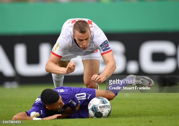 Lukas Klostermann of Leipzig is challenged by Anas Ouahim of Osnabrueck during the DFB Cup first round match between VfL Osnabrueck and RB Leipzig at...