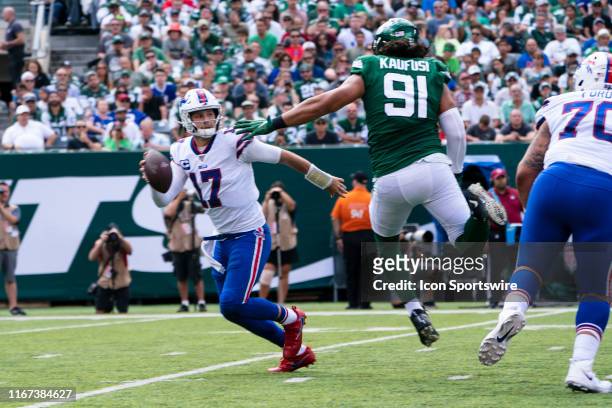 Buffalo Bills Quarterback Josh Allen rolls out to avoid pressure by New York Jets Defensive Lineman Bronson Kaufusi during the second quarter of the...