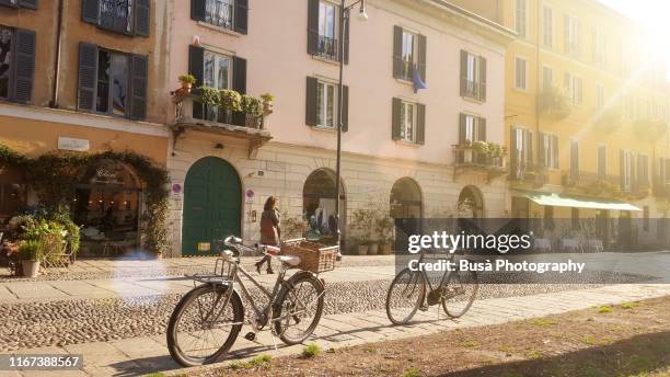 old-fashioned bikes along naviglio grande, in milan, italy, in the morning - house old bike stock-fotos und bilder