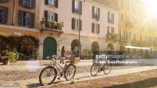 old-fashioned bikes along naviglio grande, in milan, italy, in the morning - milano navigli foto e immagini stock