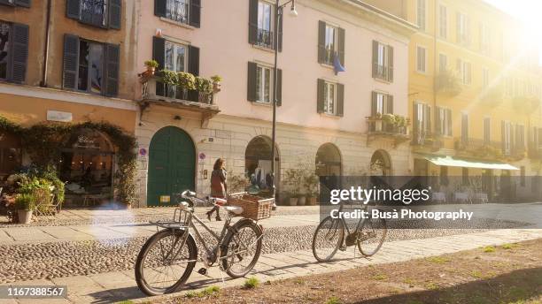 old-fashioned bikes along naviglio grande, in milan, italy, in the morning - milão imagens e fotografias de stock