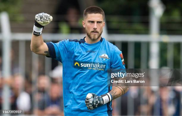 Goalkeeper Jannik Huth of Paderborn celebrates after saving a penalty of Lars Lokotsch of Roedinghausen during the DFB Cup first round match between...