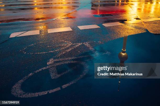 berlin city urban street night light scene with reflection a bicycle and tv tower - puddle reflection stock pictures, royalty-free photos & images