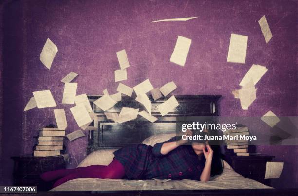 woman photographing loose sheets of a book, flying around her - flying letters stock pictures, royalty-free photos & images