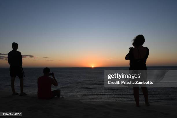 people watching the sunset from the duna do pôr do sol (sunset dune). jericoacoara, ceará, brazil - pôr do sol fotografías e imágenes de stock