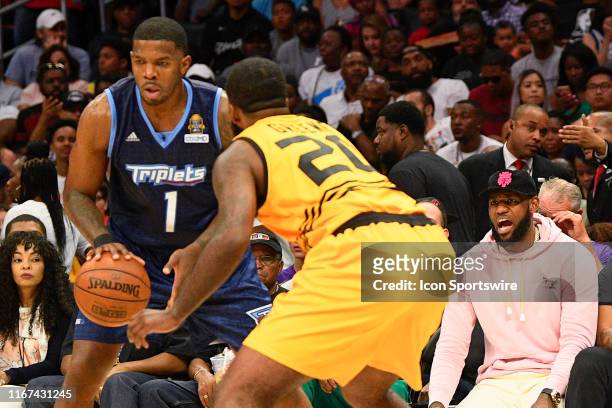 Triplets guard Joe Johnson looks to drive to the basket as Los Angeles Lakers Lebron James cheers him on during the BIG3 championship game between...