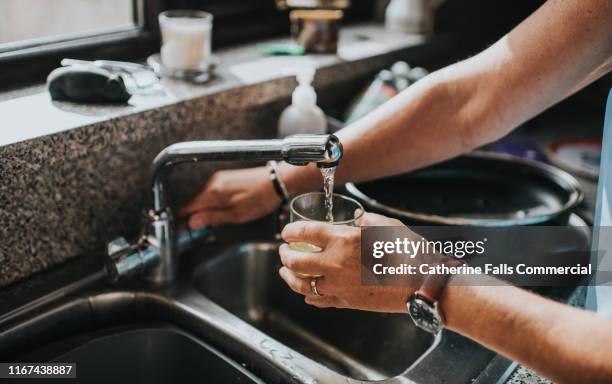 glass of water - waterkraan stockfoto's en -beelden