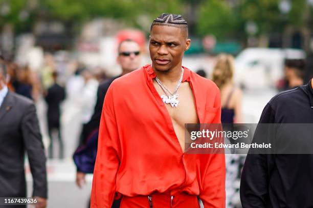 Russell Westbrook wears necklaces, an orange shirt, red pants, outside Vuitton, during Paris Fashion Week - Menswear Spring/Summer 2020, on June 20,...