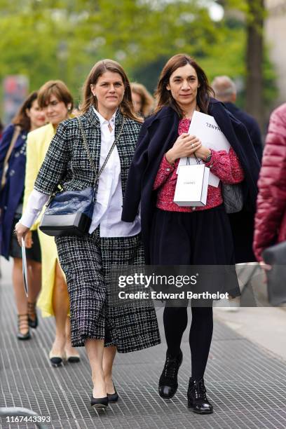 Guest wears Chanel earrings, a white Chanel shirt, a black and white Chanel jacket, a matching divided skirt, a blue and black Chanel bag, black...