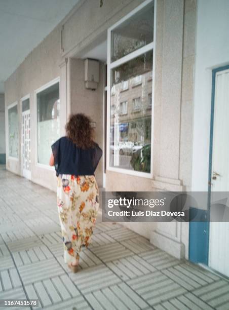 a woman walking through the city streets - street villains stock pictures, royalty-free photos & images