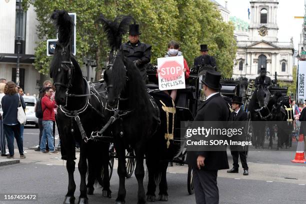 Three horse-drawn hearses carrying three symbolic adult coffins during the demonstration. Cyclists participated in a funeral procession through...