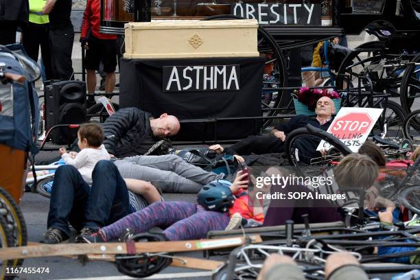 Protesters hold a die-in during the demonstration. Cyclists participated in a funeral procession through central London protesting against the death...