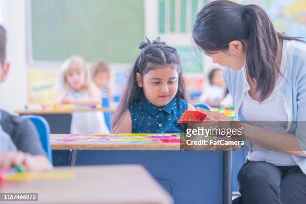 asian female teacher helping her student in class - flash card stock pictures, royalty-free photos & images