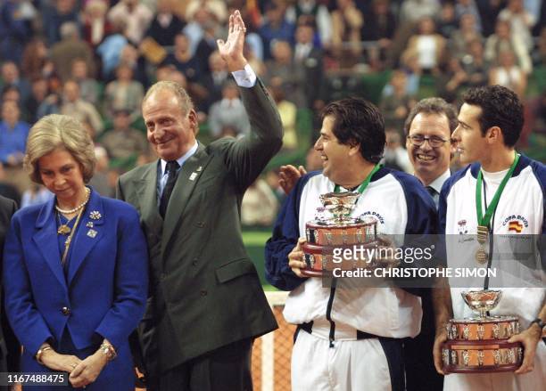 Spanish King Juan Carlos acknowledges the public beside his wife Queen Sofia while the captain of Spanish team Javier Duarte and the player Alex...