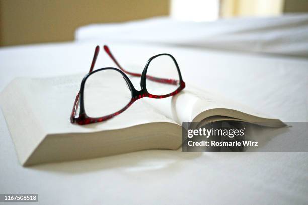 open book on white surface with eyeglasses - reading glasses - fotografias e filmes do acervo