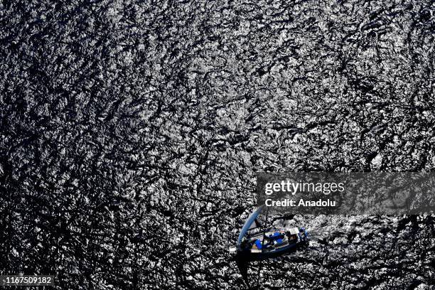An aerial view of a sailing boat going at sea near the route where test drives take place in the shakedown lap within the World Rally Championship at...