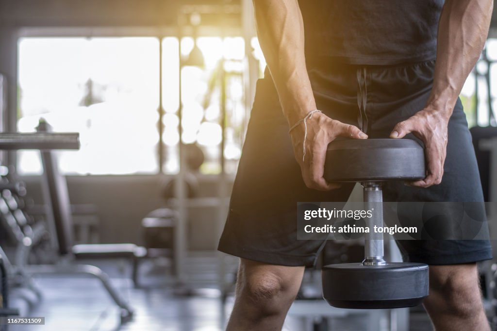 Close up of man holding weight in gym