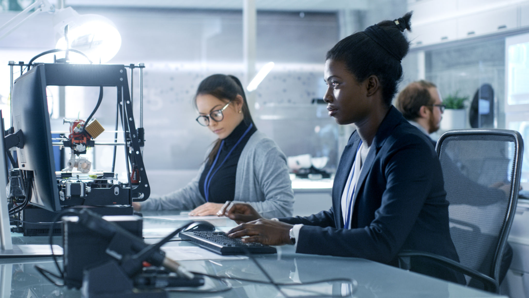 Black Female Scientist Working on a Computer with Her Colleagues at Research Center. Black Female Scientist Working on a Computer with Her Colleagues at Research Center.