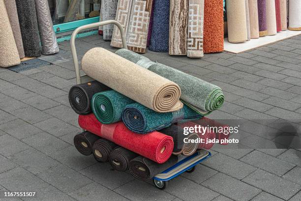 rolled up carpets in various colors - carpet roll fotografías e imágenes de stock