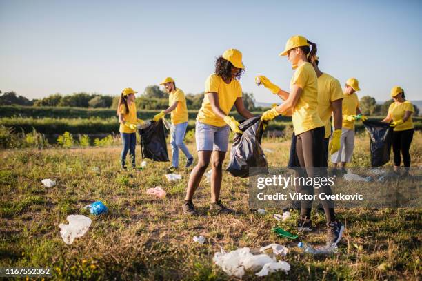 freiwillige holen gemeinsam müll im park ab - umweltschutz reinigungsaktion stock-fotos und bilder