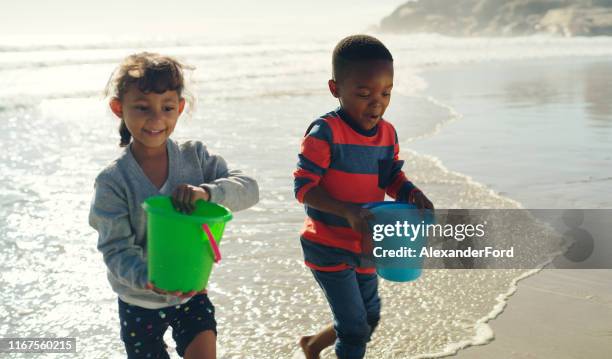 it's a race to see who builds the best sandcastle - beach bucket stock pictures, royalty-free photos & images