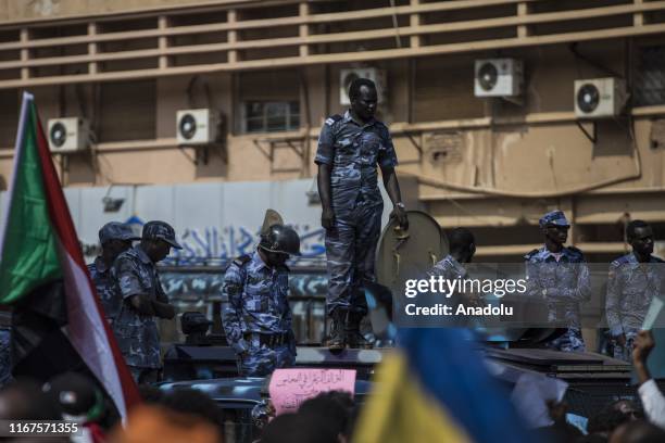 Sudanese police officers take security measures as Sudanese demonstrators gather for a demonstration demanding an attorney general and head of...