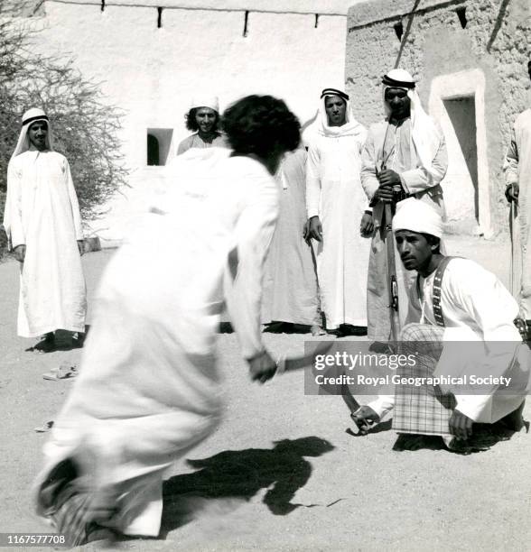 At the old fort in Buraimi Oasis soldiers of the Trucial Oman Scouts stage an Arab dance, shooting live ammunition and drawing curved knives, United...