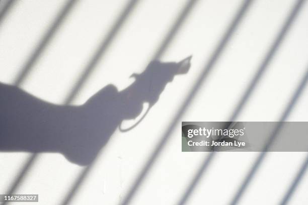 gun and jail - disparar fotografías e imágenes de stock