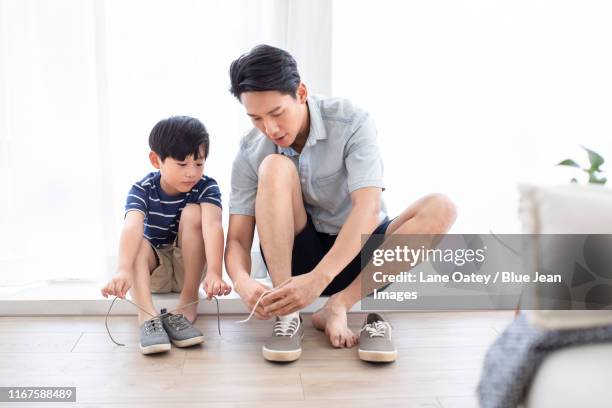 chinese father teaching his son to tie shoelaces - boy tying shoes stock-fotos und bilder