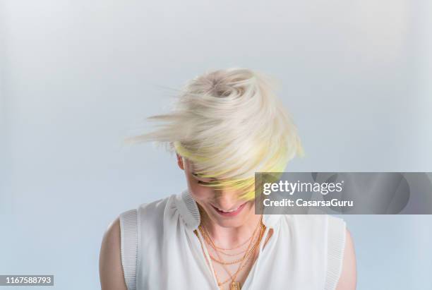 mujer joven adulta sonriente con el pelo blanqueado sobre fondo blanco - cabello blanqueado fotografías e imágenes de stock