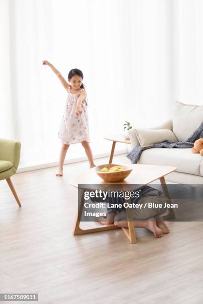 happy chinese sibling playing hide and seek in living room - kid hide and seek stock pictures, royalty-free photos & images