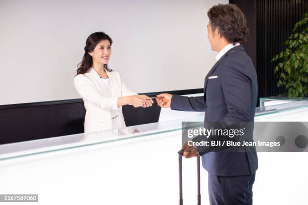 chinese receptionist giving business card to businessman - man leaving stock pictures, royalty-free photos & images