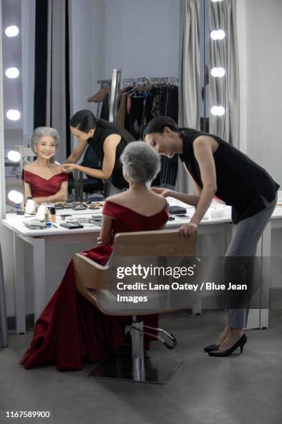 chinese makeup artist applying makeup on senior woman - パウダールーム　女性 ストックフォトと画像