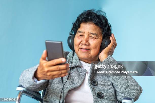 portriat of asian senoir retirement woman is listening to music in home happy lifestyle. - asian granny pics stock-fotos und bilder