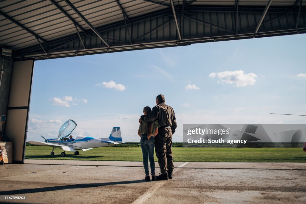 Father pilot and daughter looking at airplane